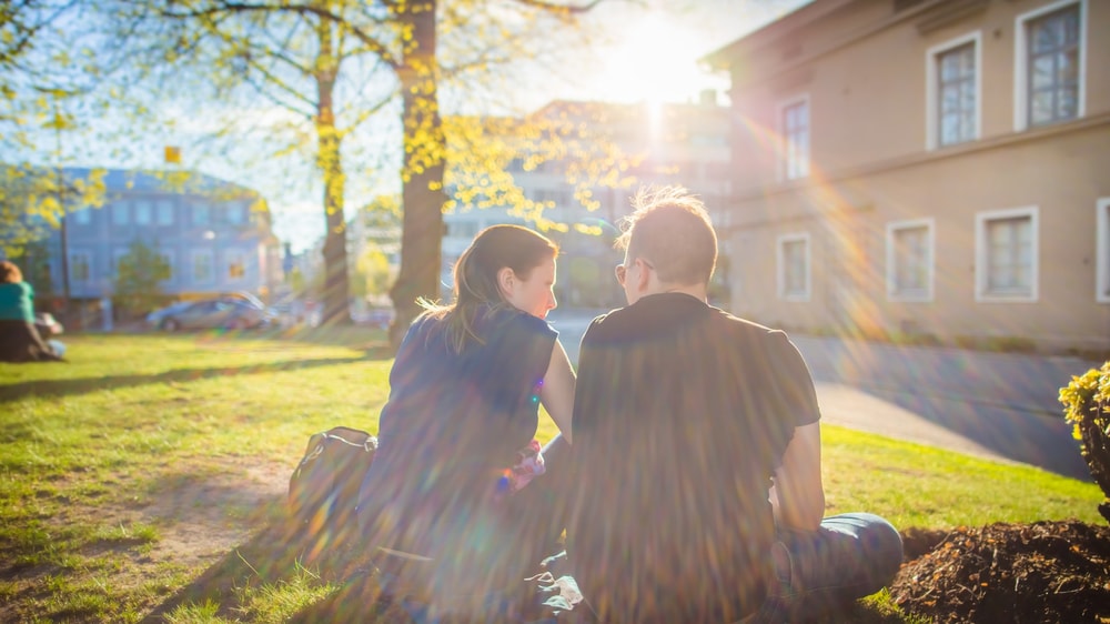 Kaksi henkilöä istumassa puistossa