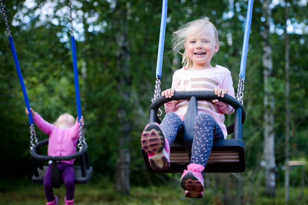 Lapsi keinuu kesällä.
